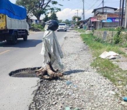 Lubang Besar di Jalinsum Medan-Sidikalang Bahayakan Pengendara, Warga Pasang Kayu Mirip Orang Sawah